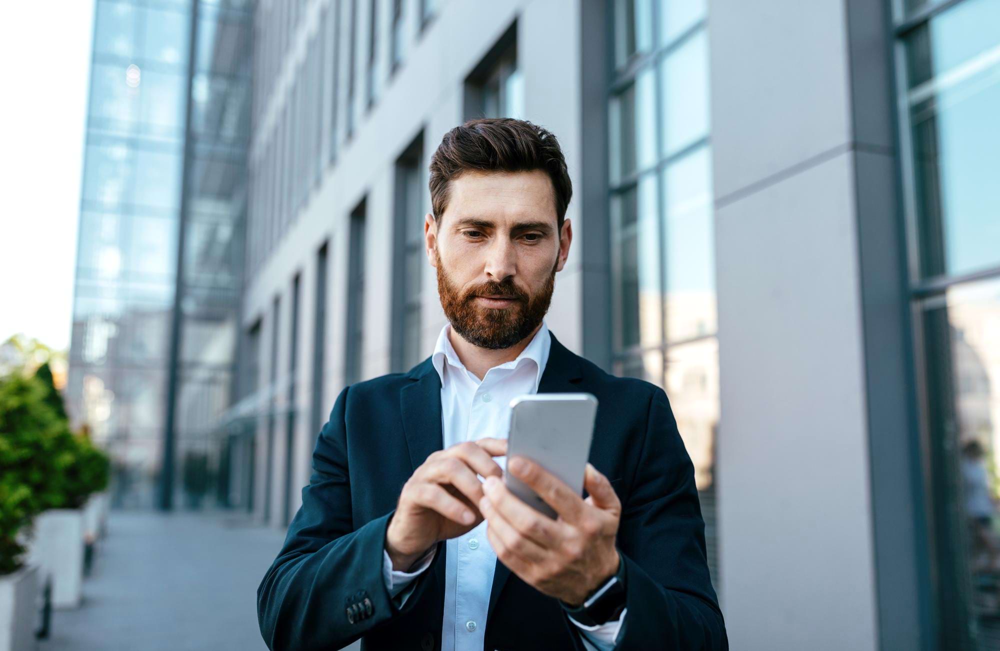 mężczyzna przegląda smartfon na ulicy